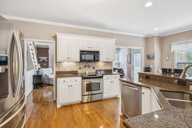1011 Brixworth Dr, Thompsons Station, TN 37179 - kitchen with stainless steel appliances, light wood-style flooring, white cabinetry, crown molding, and recessed lighting