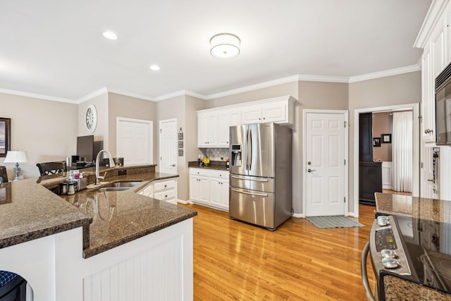 1011 Brixworth Dr, Thompsons Station, TN 37179 - kitchen with appliances with stainless steel finishes, light wood finished floors, crown molding, white cabinetry, and recessed lighting