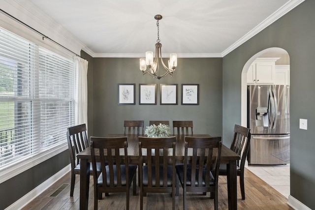 718 Excalibur Ct, Smyrna, TN 37167 - dining room with arched walkways, a chandelier, wood finished floors, and ornamental molding