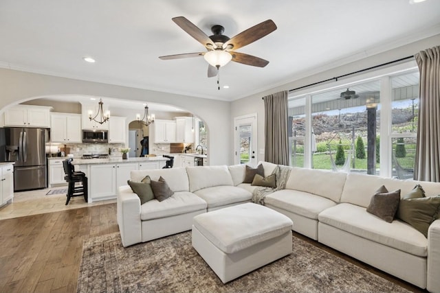 718 Excalibur Ct, Smyrna, TN 37167 - living area with arched walkways, a chandelier, crown molding, light wood-style flooring, and recessed lighting