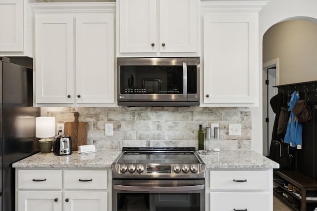 718 Excalibur Ct, Smyrna, TN 37167 - kitchen featuring stainless steel appliances, tasteful backsplash, white cabinets, and light stone counters