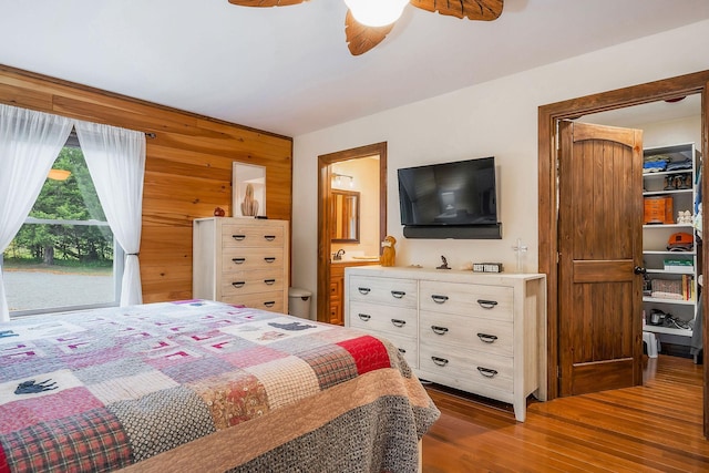 3121 Coon Hunter Lodge Rd, Jamestown, TN 38556 - bedroom with wood finished floors, wood walls, a ceiling fan, and connected bathroom