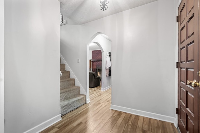 104 Chapman Dr, Lebanon, TN 37087 - entrance foyer with arched walkways, light wood finished floors, stairway, and a textured ceiling