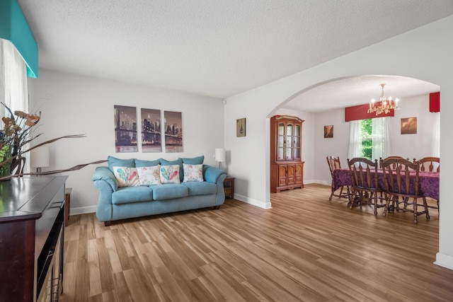 104 Chapman Dr, Lebanon, TN 37087 - living room with arched walkways, a chandelier, light wood finished floors, and a textured ceiling