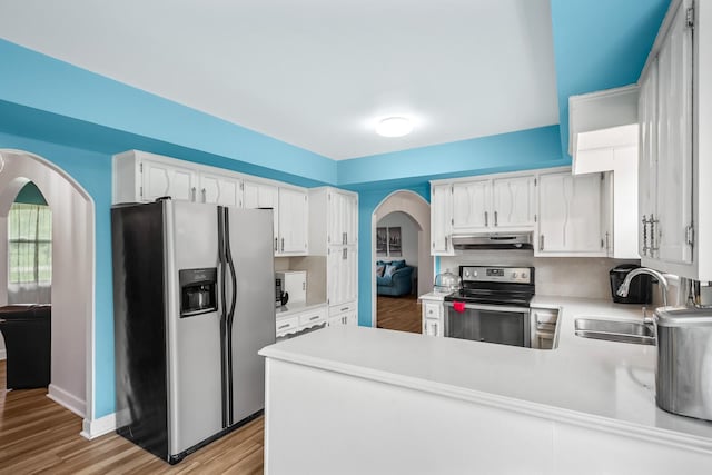 104 Chapman Dr, Lebanon, TN 37087 - kitchen with appliances with stainless steel finishes, under cabinet range hood, arched walkways, light countertops, and a peninsula