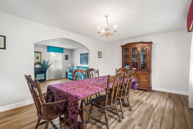 104 Chapman Dr, Lebanon, TN 37087 - dining area with arched walkways, a chandelier, light wood-style flooring, and a textured ceiling
