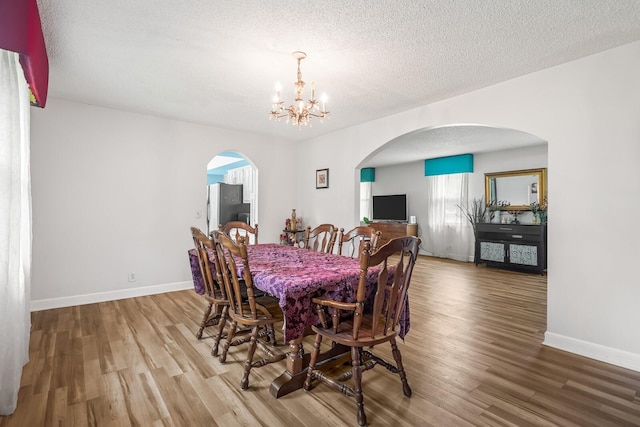 104 Chapman Dr, Lebanon, TN 37087 - dining area with a chandelier, wood finished floors, arched walkways, and a textured ceiling