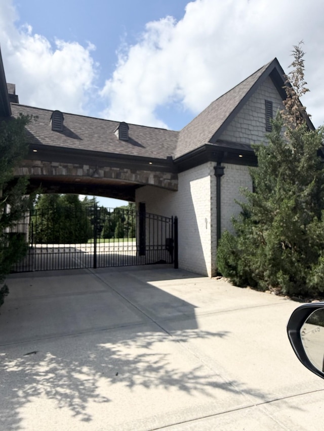 1430 Avellino Cir, Murfreesboro, TN 37130 - view of side of home with a gate, driveway, brick siding, roof with shingles, and a carport
