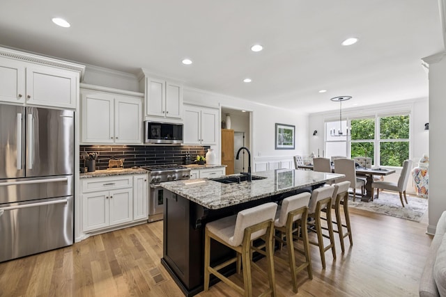 967 Nashs Nook, Columbia, TN 38401 - kitchen featuring stainless steel appliances, white cabinets, light stone countertops, light wood-type flooring, and decorative backsplash