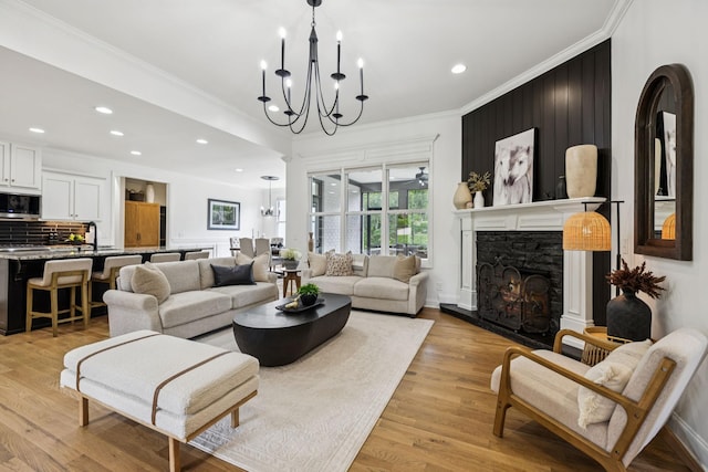 967 Nashs Nook, Columbia, TN 38401 - living room featuring a chandelier, crown molding, a warm lit fireplace, recessed lighting, and light wood-style flooring