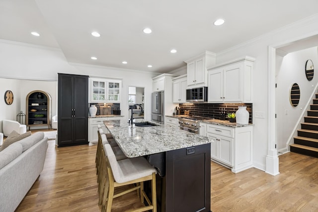 967 Nashs Nook, Columbia, TN 38401 - kitchen featuring premium appliances, backsplash, a breakfast bar area, a center island with sink, and white cabinetry