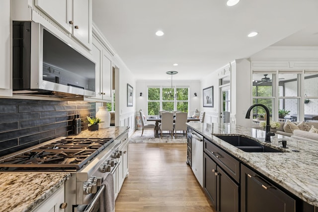 967 Nashs Nook, Columbia, TN 38401 - kitchen featuring appliances with stainless steel finishes, light wood finished floors, tasteful backsplash, white cabinets, and light stone countertops
