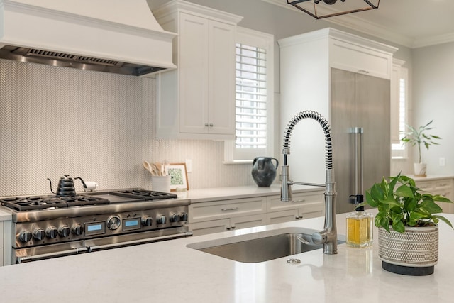 1014B Noelton Ave, Nashville, TN 37204 - kitchen with custom exhaust hood, range with two ovens, decorative backsplash, white cabinetry, and crown molding