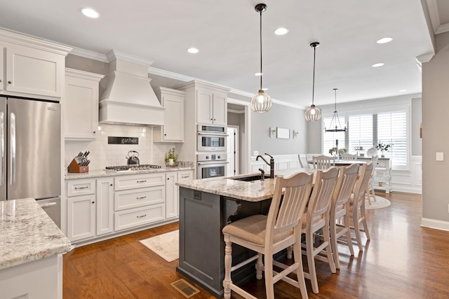 2003 Imagine Cir, Spring Hill, TN 37174 - kitchen featuring stainless steel appliances, wall chimney range hood, backsplash, white cabinets, and dark wood-style flooring