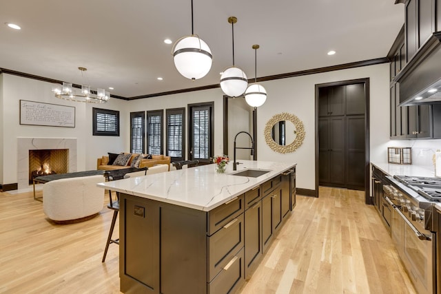 325 Fairpark Ct, Franklin, TN 37064 - kitchen with double oven range, crown molding, light wood-style floors, a center island with sink, and light stone counters