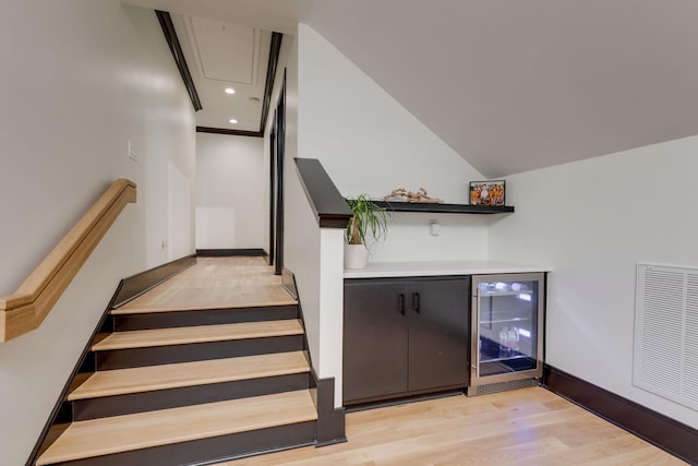 325 Fairpark Ct, Franklin, TN 37064 - stairs featuring beverage cooler, wood finished floors, a bar, attic access, and recessed lighting