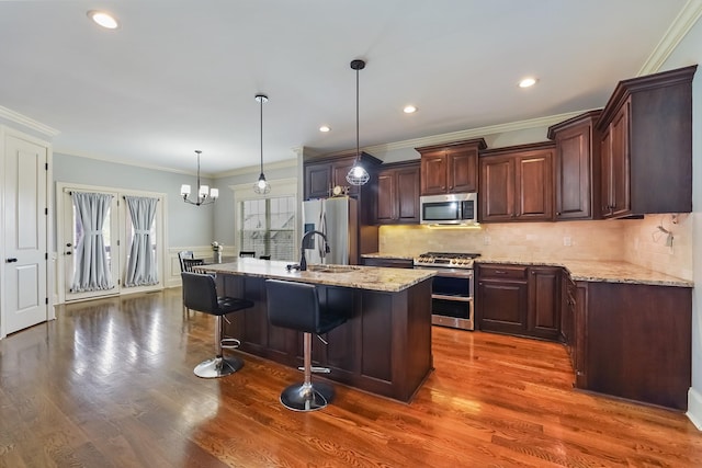 600 Southshore Pt, Mount Juliet, TN 37122 - kitchen featuring appliances with stainless steel finishes, crown molding, a chandelier, light stone counters, and a kitchen bar