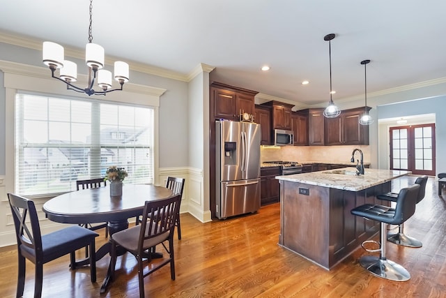 600 Southshore Pt, Mount Juliet, TN 37122 - kitchen with stainless steel appliances, a chandelier, light stone countertops, a kitchen island with sink, and wood finished floors