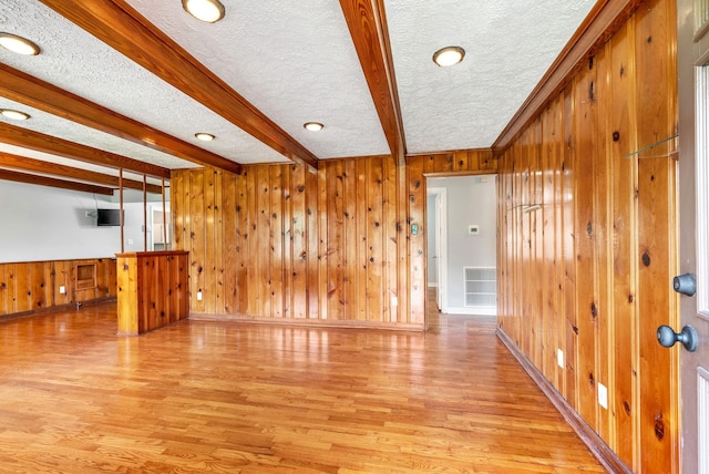 3509 Lafayette Rd, Hopkinsville, KY 42240 - unfurnished living room featuring a textured ceiling, beam ceiling, wood walls, light wood-type flooring, and recessed lighting