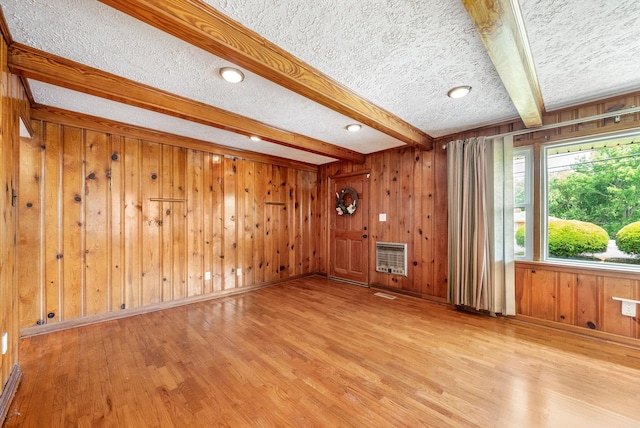 3509 Lafayette Rd, Hopkinsville, KY 42240 - unfurnished living room with wood finished floors, beam ceiling, wood walls, a textured ceiling, and heating unit