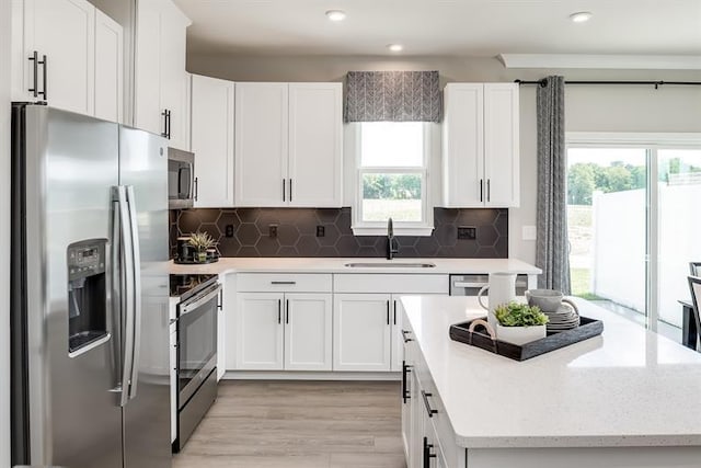 4000 Gaskill Dr Unit 122A, Smyrna, TN 37167 - kitchen featuring stainless steel appliances, a center island, white cabinets, light wood-style floors, and tasteful backsplash