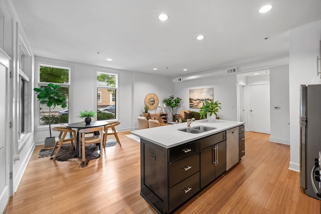 201 S 11th St, Nashville, TN 37206 - kitchen with stainless steel dishwasher, freestanding refrigerator, a center island with sink, light countertops, and light wood-type flooring