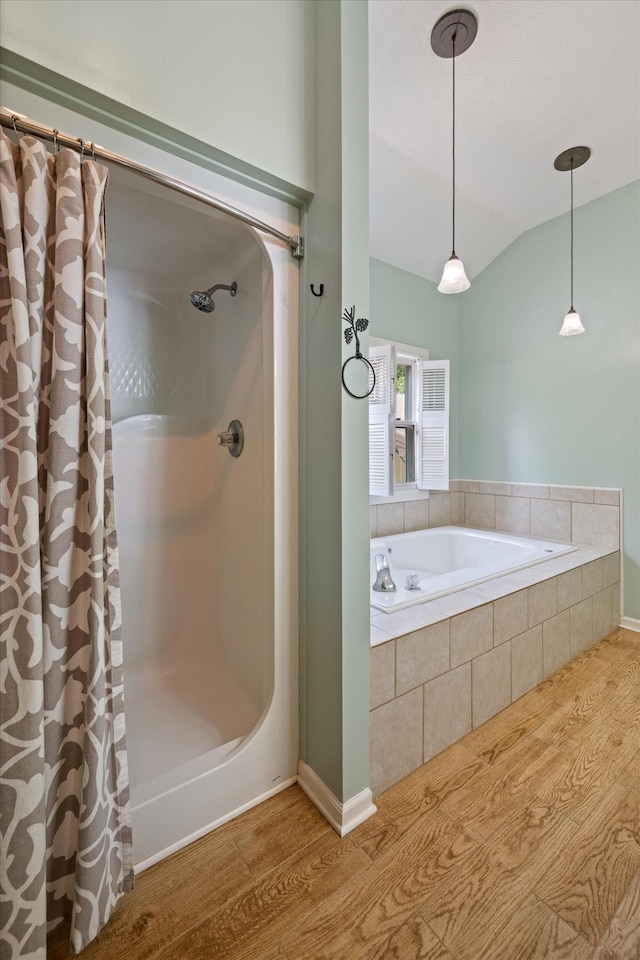 191 Spicer Rd, Burns, TN 37029 - full bathroom with wood finished floors, tiled tub, a shower with shower curtain, and vaulted ceiling