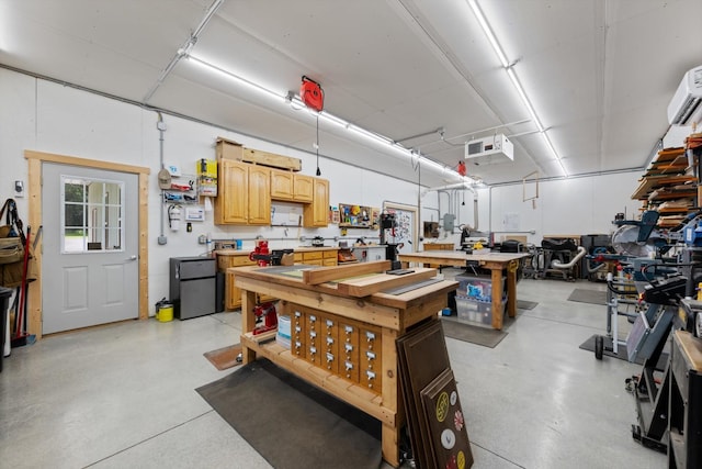 191 Spicer Rd, Burns, TN 37029 - garage featuring a workshop area, a wall mounted AC, and refrigerator