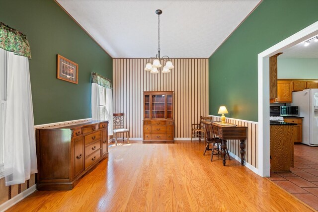 191 Spicer Rd, Burns, TN 37029 - dining area with a chandelier, vaulted ceiling, an accent wall, and light wood finished floors