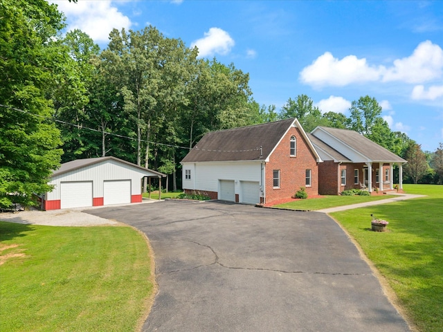191 Spicer Rd, Burns, TN 37029 - view of front facade featuring a garage, brick siding, a front lawn, and an outdoor structure