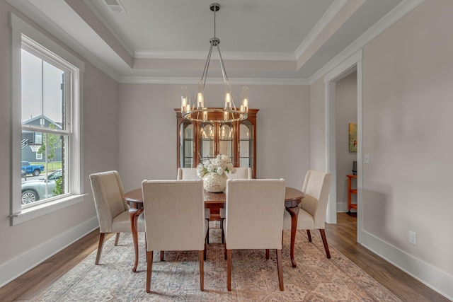 1074 Amelia Park Dr, Franklin, TN 37067 - dining room with a chandelier, a tray ceiling, wood finished floors, and crown molding