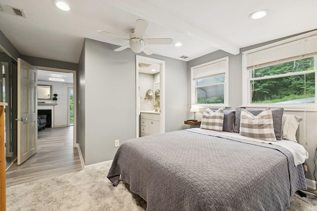 617 Still Point Rd, Smithville, TN 37166 - bedroom with light wood-style flooring, recessed lighting, a glass covered fireplace, beamed ceiling, and connected bathroom