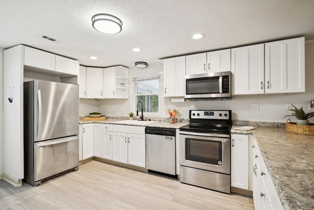 617 Still Point Rd, Smithville, TN 37166 - kitchen with appliances with stainless steel finishes, light wood-type flooring, white cabinets, a textured ceiling, and open shelves