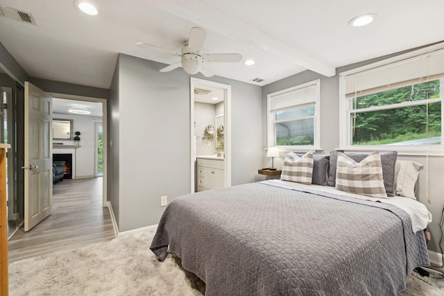 617 Still Point Rd, Smithville, TN 37166 - bedroom with light wood-type flooring, recessed lighting, a glass covered fireplace, beam ceiling, and connected bathroom