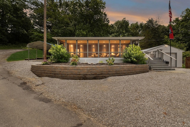 617 Still Point Rd, Smithville, TN 37166 - back of house at dusk with an outdoor structure and a sunroom