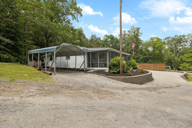 617 Still Point Rd, Smithville, TN 37166 - view of front of house featuring a detached carport, a sunroom, driveway, and view of scattered trees