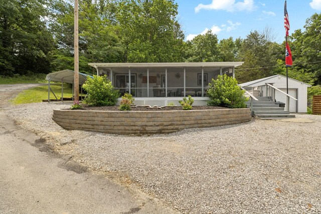 617 Still Point Rd, Smithville, TN 37166 - back of property with a sunroom, an outbuilding, gravel driveway, and view of wooded area