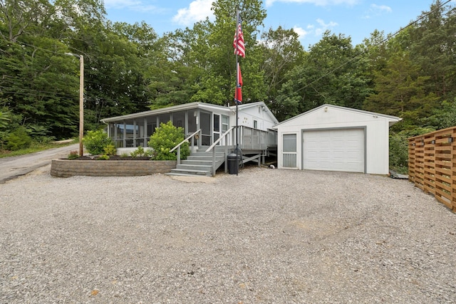 617 Still Point Rd, Smithville, TN 37166 - manufactured / mobile home featuring a sunroom, gravel driveway, an outbuilding, and a garage