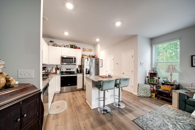 701 Dallas Dr, Columbia, TN 38401 - kitchen with appliances with stainless steel finishes, a kitchen bar, white cabinets, light wood finished floors, and recessed lighting