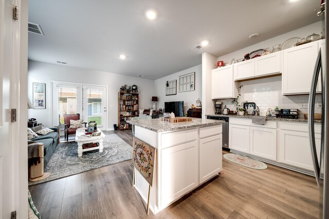 701 Dallas Dr, Columbia, TN 38401 - kitchen featuring stainless steel appliances, open floor plan, light wood-type flooring, white cabinets, and light stone countertops