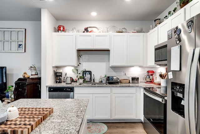 701 Dallas Dr, Columbia, TN 38401 - kitchen with stainless steel appliances, tasteful backsplash, white cabinets, wood finished floors, and recessed lighting