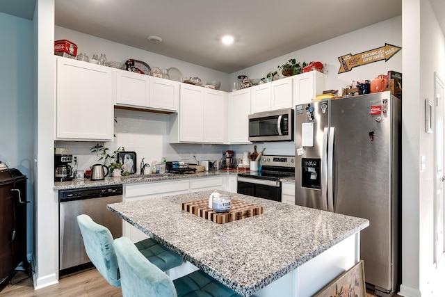 701 Dallas Dr, Columbia, TN 38401 - kitchen featuring appliances with stainless steel finishes, white cabinets, light stone countertops, light wood-style flooring, and recessed lighting