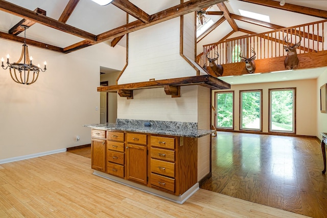 5141 Tranham Rd, Whites Creek, TN 37189 - kitchen featuring beamed ceiling, brown cabinets, light wood-type flooring, a chandelier, and a skylight