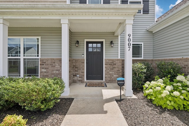 9007 Outpost Dr, Spring Hill, TN 37174 - view of exterior entry featuring brick siding and a porch