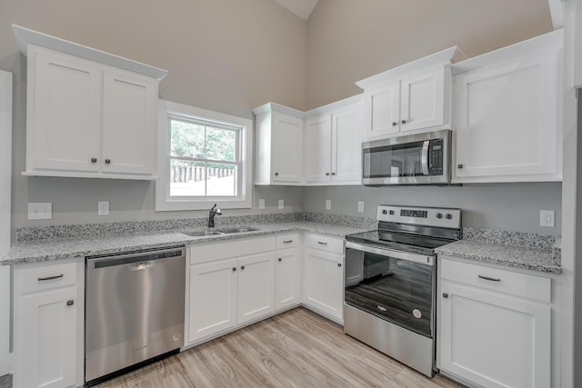 514 Haviture Way, Murfreesboro, TN 37129 - kitchen with appliances with stainless steel finishes, white cabinets, light wood-type flooring, light stone counters, and high vaulted ceiling