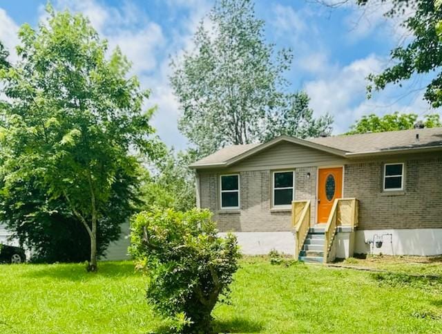 209 Granada Dr, Columbia, TN 38401 - rear view of property with brick siding and a lawn