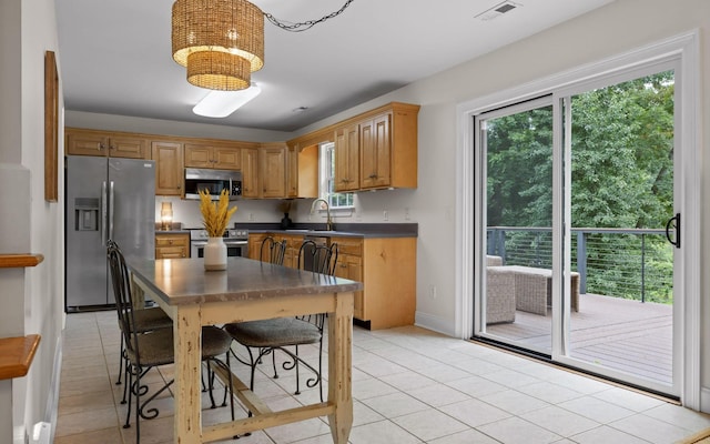 750 S Seminole Dr, Chattanooga, TN 37412 - kitchen with stainless steel appliances, dark countertops, light tile patterned floors, and a chandelier