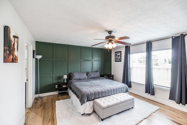 1004 Meridian Dr, Castalian Springs, TN 37031 - bedroom featuring a textured ceiling, light wood finished floors, a decorative wall, and ceiling fan