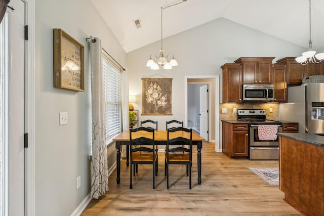 3022 Honeysuckle Dr, Spring Hill, TN 37174 - kitchen with stainless steel appliances, a chandelier, dark countertops, decorative backsplash, and light wood finished floors