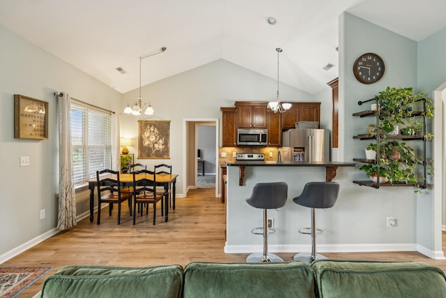 3022 Honeysuckle Dr, Spring Hill, TN 37174 - kitchen featuring stainless steel appliances, a chandelier, a breakfast bar, dark countertops, and vaulted ceiling